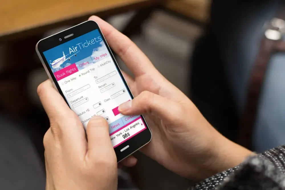 Close up of woman using smartphone to look at flights
